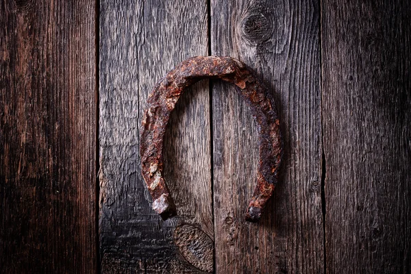 Símbolo de suerte de herradura antiguo oxidado sobre fondo de madera vintage — Foto de Stock