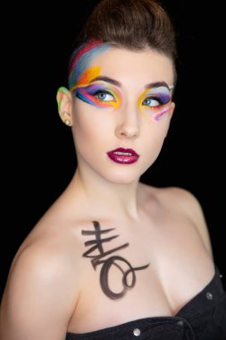 Yaratıcı makyajı ve vücut boyası olan genç ve çekici bir kadın.