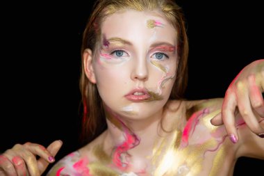 Yüzünde yaratıcı makyajı olan çekici bir genç kadın.