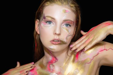 Yüzünde yaratıcı bir makyajı olan sevimli genç bir kadın.