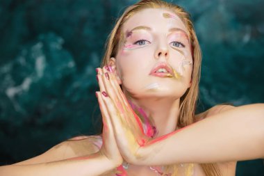 Yaratıcı makyajlı ve vücut boyalı genç seksi kadın.