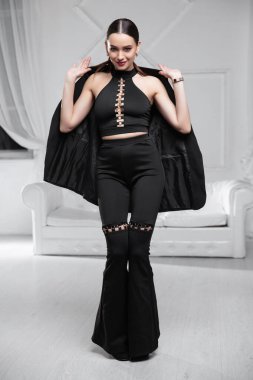 Siyah büstiyer giymiş, stüdyoda poz veren güzel bir esmer.