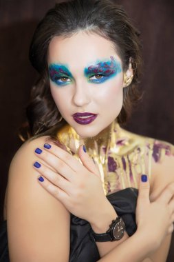 Yüzünde yaratıcı bir makyajı olan güzel bir kadının portresi.