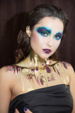 Yüzünde yaratıcı bir makyajı olan genç ve tatlı bir kadının portresi.