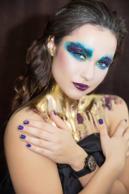 Yüzünde yaratıcı bir makyajı olan genç bir kadının portresi.