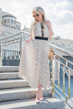 Merdivenlerde poz veren uzun elbiseli hoş bir genç bayan.