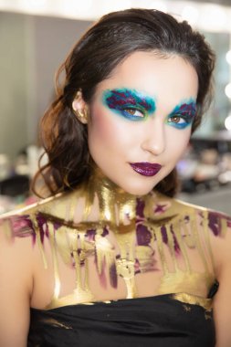 Güzel, genç esmer, yaratıcı makyajlı ve vücut boyalı.