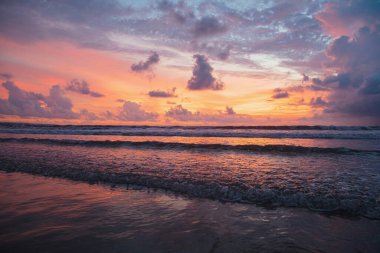 Endonezya 'nın Bali adasındaki Kuta plajında büyük, kızıl gün batımı manzarası