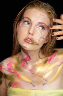 Yüzünde yaratıcı bir makyajı olan çekici bir genç kadının portresi.