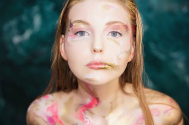 Yaratıcı makyajı ve vücut boyası olan genç ve hoş bir kadın.