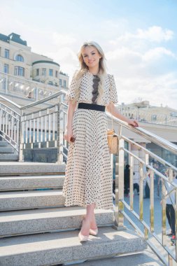 Merdivenlerde poz veren uzun elbiseli hoş bir genç bayan.