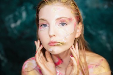 Yaratıcı makyajı ve vücut boyası olan çekici bir kadın.