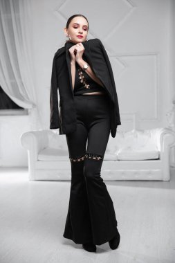 Siyah büstiyer giymiş, stüdyoda poz veren güzel bir esmer.