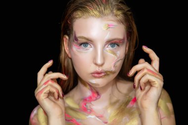 Yüzünde yaratıcı bir makyajı olan güzel genç bir kadın.