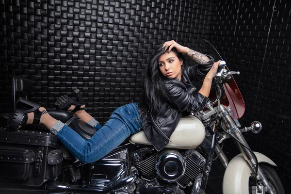Deri Ceketli Kot Pantolonlu Güzel Bir Bayan Motosikletin Üzerinde Yatıyor — Stok fotoğraf