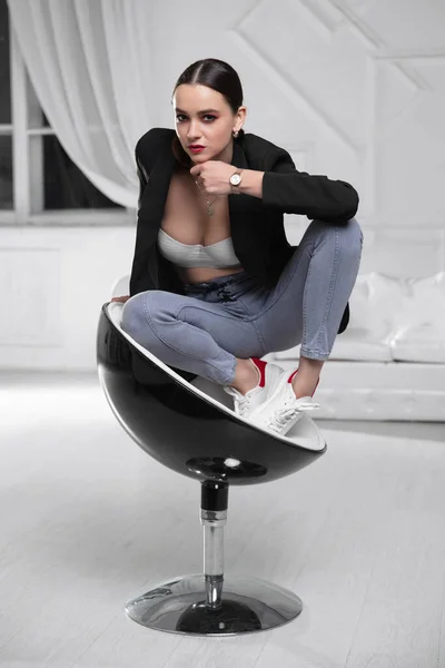 Mooie Dame Een Jas Beha Jeans Zittend Een Fauteuil — Stockfoto