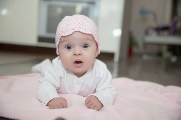 白いスライダーと帽子を被った可愛い赤ちゃんがピンクの服を着て — ストック写真