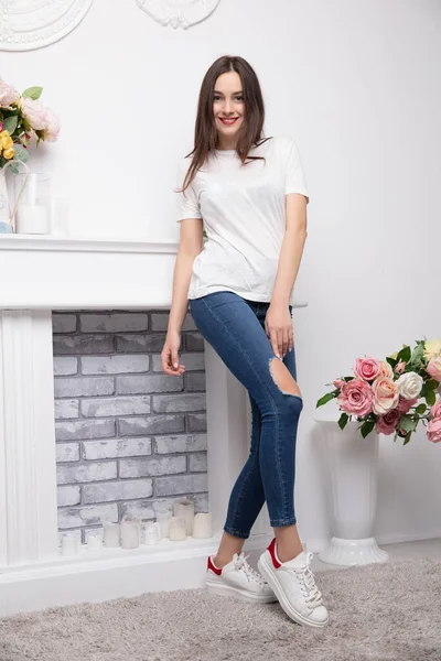Bonita Morena Vestida Con Jeans Una Camiseta Posando Cerca Chimenea —  Fotos de Stock