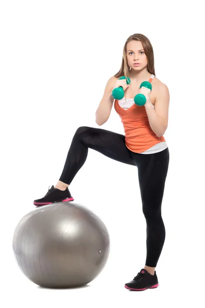 Mulher posando com bola em forma e halteres — Fotografia de Stock