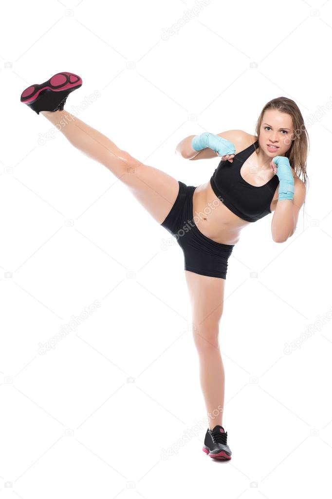 Woman in sport clothes kicking