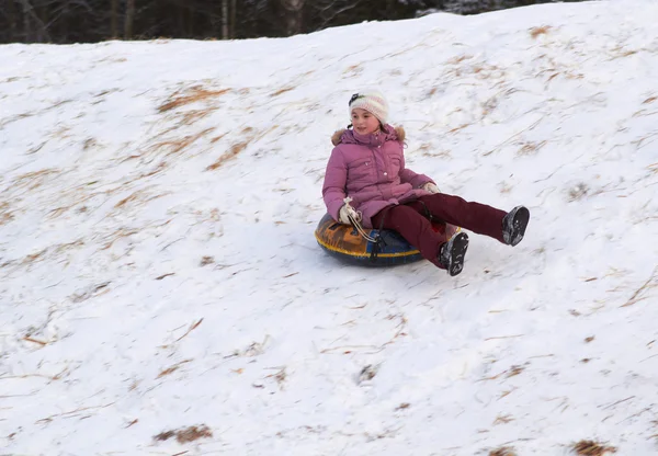 Ευτυχισμένος εφηβικό κορίτσι συρόμενη κάτω στο χιόνι tube — Φωτογραφία Αρχείου
