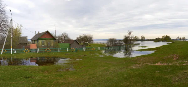 Panorama primaverile con il fiume in piena giornata nuvolosa Foto Stock