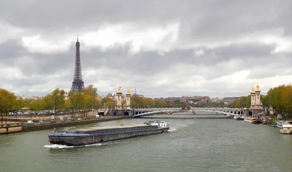 Eiffel Tower on the bank of river Seine with ship spring cloudy day — Stock Photo, Image