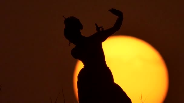 Silhouette fille danseuse orientale une danse sur le coucher du soleil 