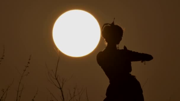 Silhueta menina oriental dançarina uma dança no por do sol — Vídeo de Stock