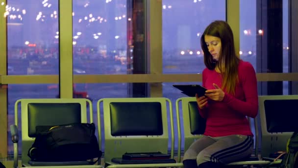 Jeune passagère à l'aéroport, utilisant sa tablette — Video