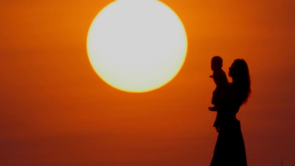 Щаслива мати і маленька дочка грають на заході сонця — стокове відео
