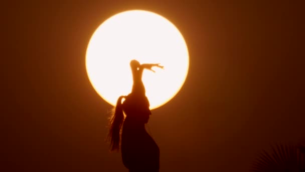 Счастливая свободная женщина наслаждается закатом моря. Силуэт против заката, восход солнца на ладони — стоковое видео