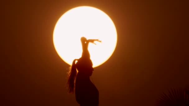 Happy free Woman enjoying in Sea Sunset. Silhouetted against the sunset, sunrise Sun on the palm — Stock Video