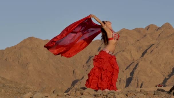 Красивая девушка танцует этнические танцы в пустыне — стоковое видео