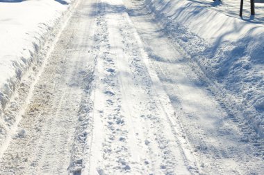 Kış yolu karla kaplı. Taze kar yağışı sokağı. Karlı yol. Güneş ışığında kar taneleri ve buz