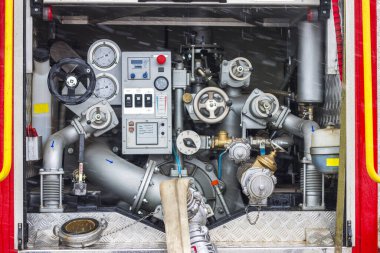 İtfaiye ekipmanları arabanın arkasında. Kırmızı itfaiye aracının arka tarafını su kaynağıyla aç