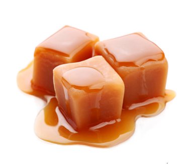 Beyaz arka planda karamel kaplı tatlı karamel şekerler..