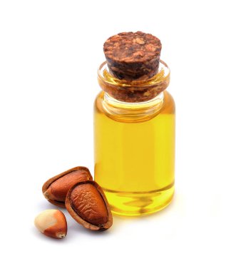 Beyaz arka planda Oleoresin yağı ve çam fıstığı. Şişe üzerindeki sedir yağı. Yakın plan..