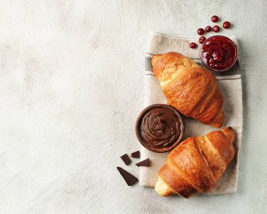 Çikolatalı kruvasan ve kızılcık reçeli. Klasik kahvaltı. Yakın plan..