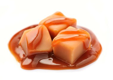 Beyaz arka planda karamel kaplı karamel şekerler..