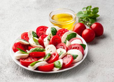 Domatesli İtalyan caprese salatası ve fesleğen yapraklı mozzarella peyniri. 
