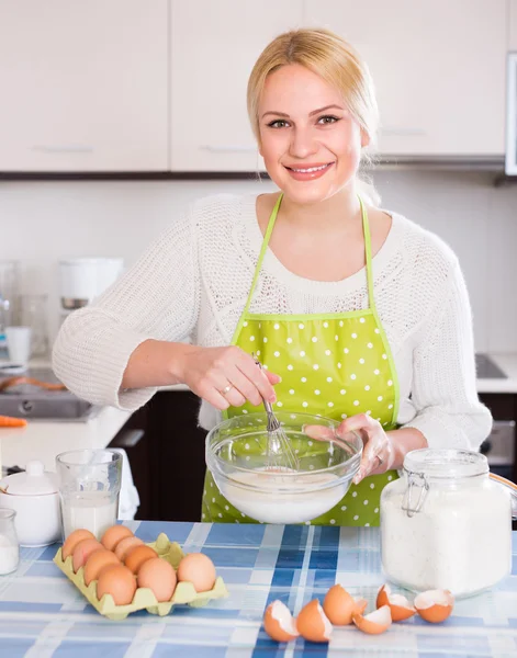 Housewife beating eggs and milk — Stock Photo, Image