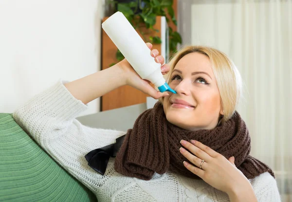 Ung blondin med nässpray — Stockfoto