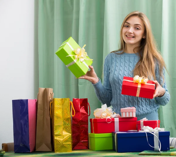 Girl sitting at table with many presents — Stock Photo, Image