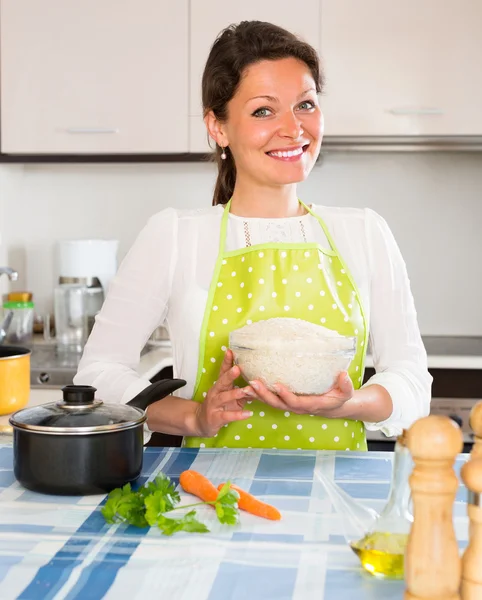 Vrouw kookt rijst in de keuken — Stockfoto