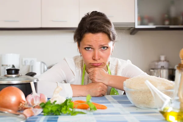 Θλιβερή γυναίκα μαγείρεμα ρυζιού στην κουζίνα — Φωτογραφία Αρχείου