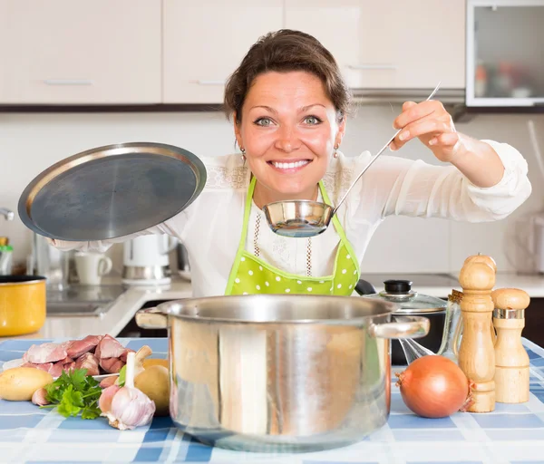 Housewife cooking meat and potatoes — Stock Photo, Image