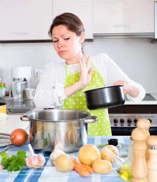 Donna con padella puzzolente in cucina — Foto Stock