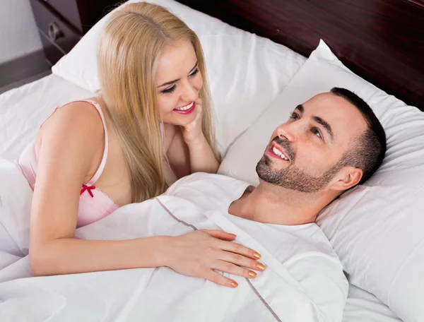 Gelukkige positieve paar poseren in bed — Stockfoto