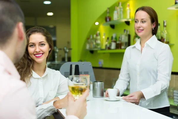 Sorrindo mulher barista e dois clientes — Fotografia de Stock